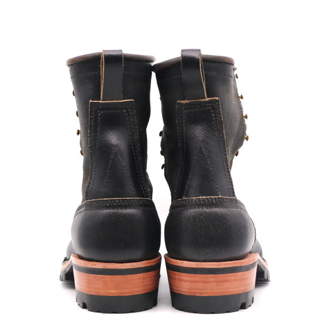 A pair of black leather lace-up boots shown from the back, featuring a chunky brown and black stacked sole.