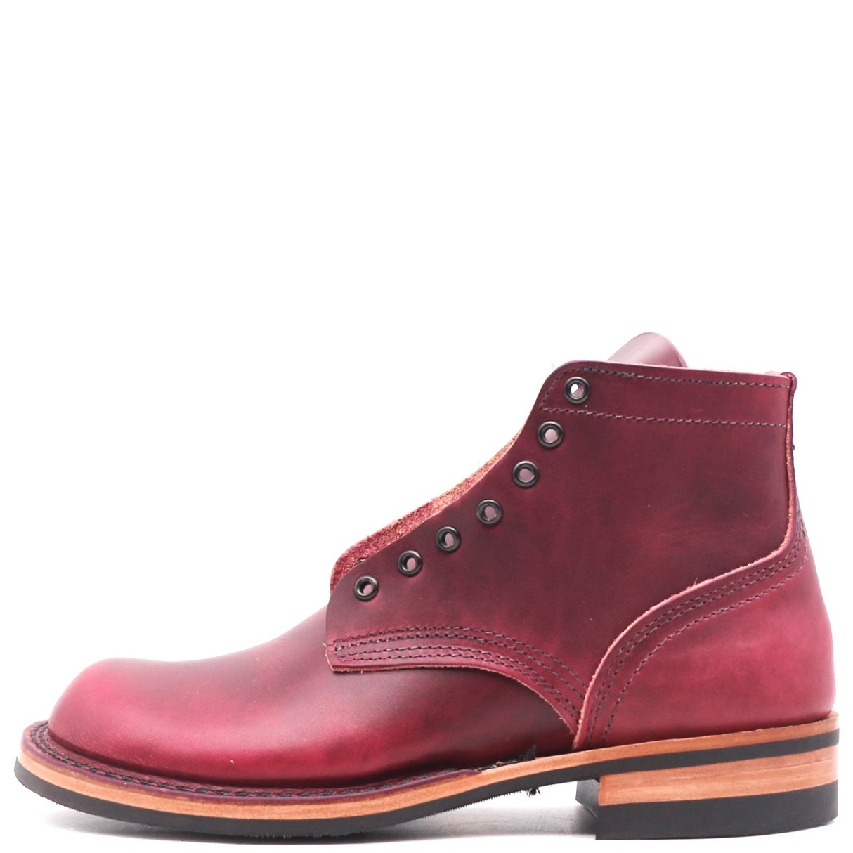 A single men's leather ankle boot in a deep burgundy red, featuring decorative metal eyelets, a stacked leather sole with a tan midlayer and black outsole, shown from a side profile on a white background.