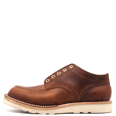 Brown ankle boot with wedge outsole and brass outlets in front of a white background.