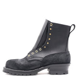 A black leather and suede lace-up ankle boot with gold-tone metal eyelets and studs, a pull tab, and a chunky lug sole, shown from a side profile on a white background.