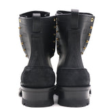 A pair of black leather and suede ankle boots with gold-tone metal studs, shown from the back against a white background.