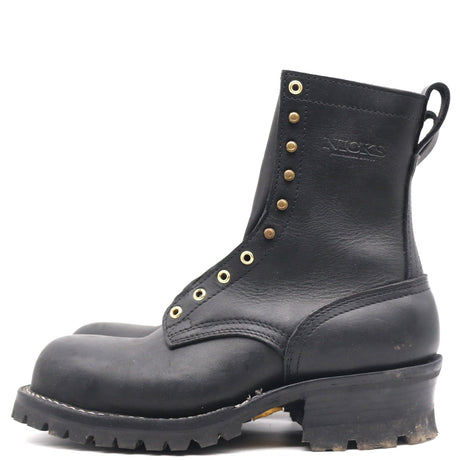 A black leather work boot with gold-tone metal eyelets and studs, featuring a pull tab and a rugged lug sole, shown from a side profile on a white background.