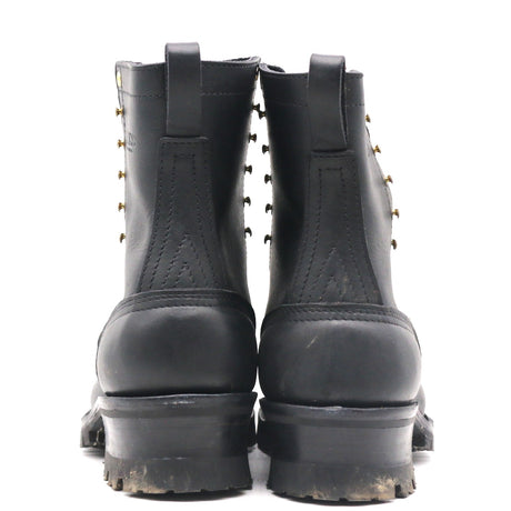 A pair of black leather lace-up ankle boots shown from the back, featuring brass grommets and thick lug soles, set against a plain white background.