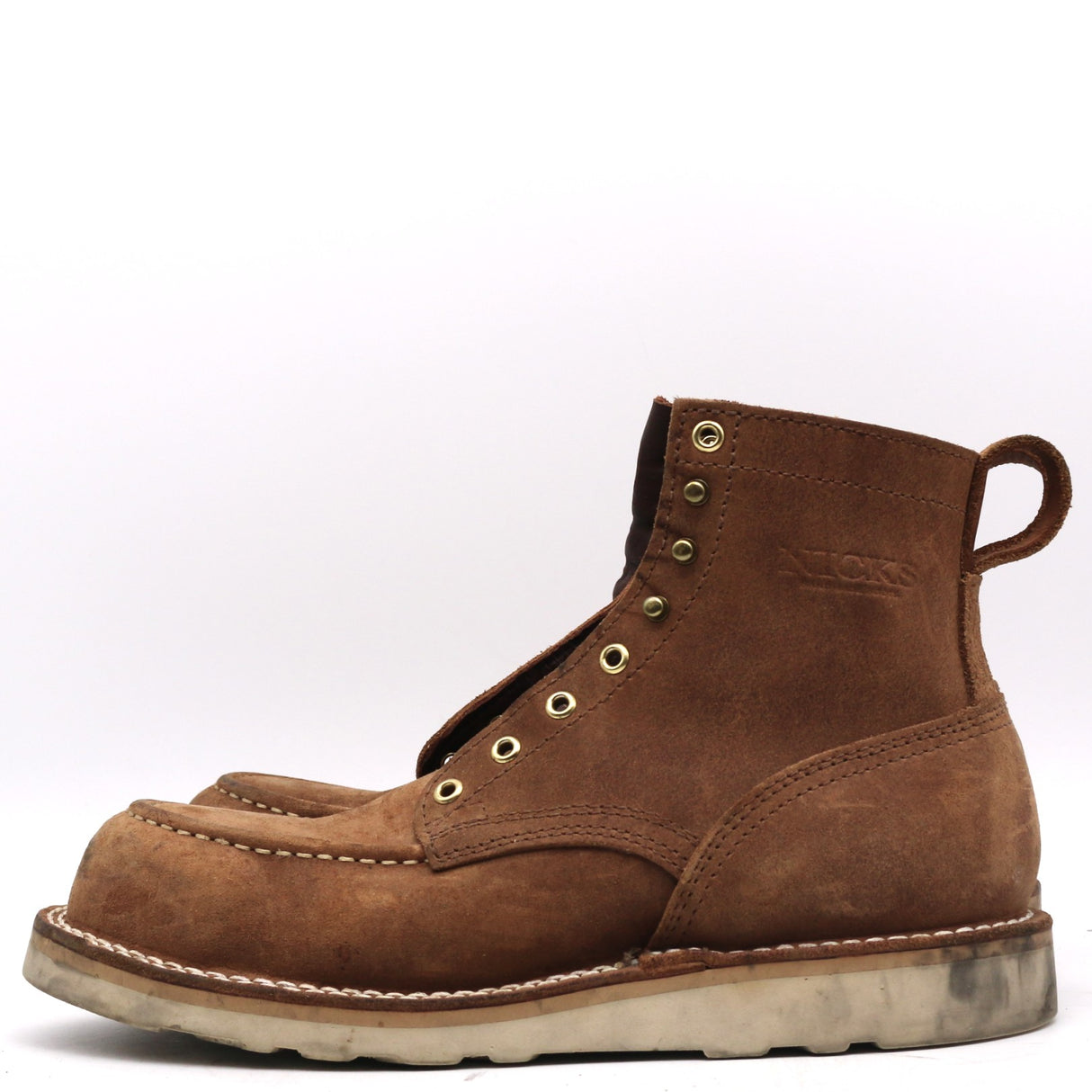 A single brown suede lace-up boot with brass eyelets and a pull tab, shown from a side profile on a white background.