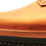Close-up of a tan leather boot showing the side panel, stitching, and a portion of the black outsole.