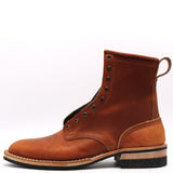 A single brown leather ankle boot with metal eyelets, a pull loop, and a stacked sole, shown from the side on a white background.