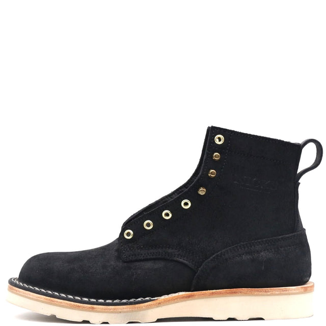 A black suede ankle boot with gold-tone metal eyelets, a pull tab, and a thick off-white sole, shown from a side profile on a white background.