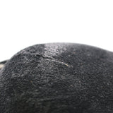 A close-up of a black felt or wool-like textured surface against a plain white background.