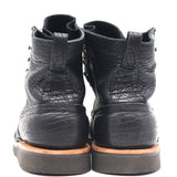 A pair of black leather ankle boots with a textured, cracked finish, shown from the back against a plain white background.