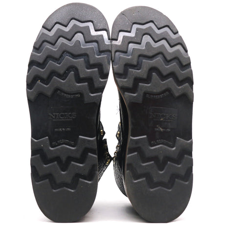The treaded black rubber soles of a pair of boots, shown from the bottom against a white background. The brand name 'NICKS' is embossed on the center of each sole.