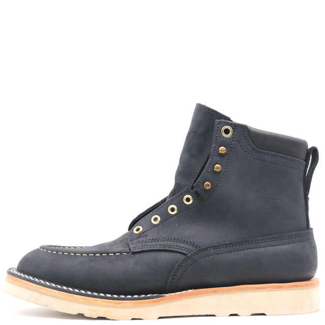 A single dark navy suede lace-up ankle boot with brass eyelets and a light tan sole, shown from a side profile on a white background.