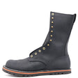 Tall black boot built on a zero-drop flat last with brass hardware in front of a while background.