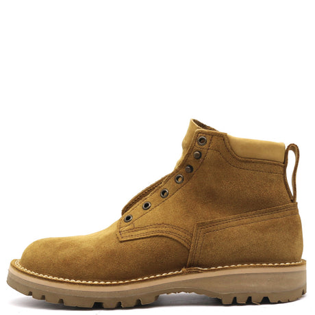 A single men's ankle boot in tan suede with dark metal eyelets, a pull tab, and a thick lug sole, shown from a side profile on a white background.