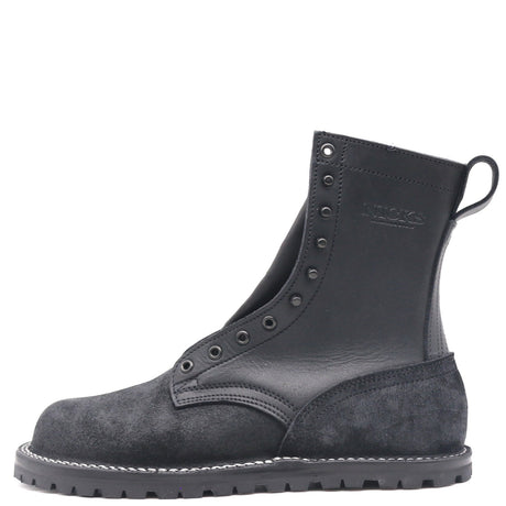 A single black leather and suede ankle boot with metal eyelets, white contrast stitching, and a pull tab on the heel, shown from a side profile on a white background.