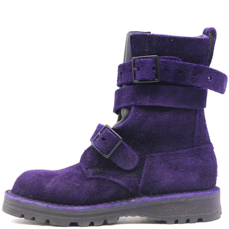A single purple suede ankle boot with two adjustable strap closures and black buckles, shown from a side profile on a white background.