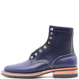 A navy blue leather lace-up boot with gold-tone metal eyelets and a stacked black and tan sole, shown from a side profile on a white background.