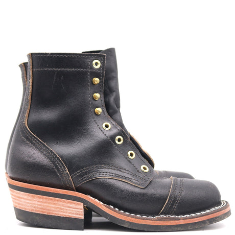 A single black leather lace-up ankle boot with gold-tone metal eyelets, a stacked wood-look heel, and contrast stitching, shown against a plain white background.