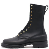 A black leather lace-up combat boot with gold-tone metal eyelets and studs, featuring a pull tab at the top, shown from a side profile on a white background.