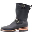 A black leather mid-calf boot with gold-tone buckle straps, a pull tab, and a stacked sole with a light brown mid-layer, shown against a plain white background.