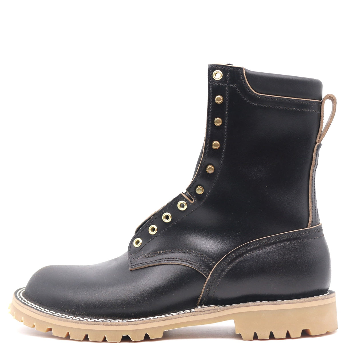 Black eight inch boots with padded collar, brass hardware, and a honey unit lug outsole in front of a white background.