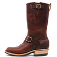 A dark brown leather mid-calf boot with brass buckle straps, a stacked wood-look heel, and a black outsole, shown from a side profile on a white background.