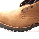 Close-up of a tan suede work boot showing the side profile with metal eyelets, contrast stitching, and a dark lug sole on a white background.