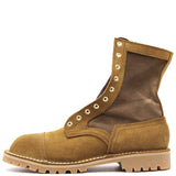 A single mid-calf lace-up boot in tan suede and dark brown fabric, featuring brass-tone metal eyelets and a chunky lug sole, shown against a plain white background.