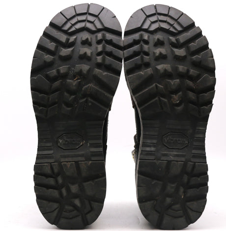 Pair of worn black outsoles with pronounced tread shown against a white background.