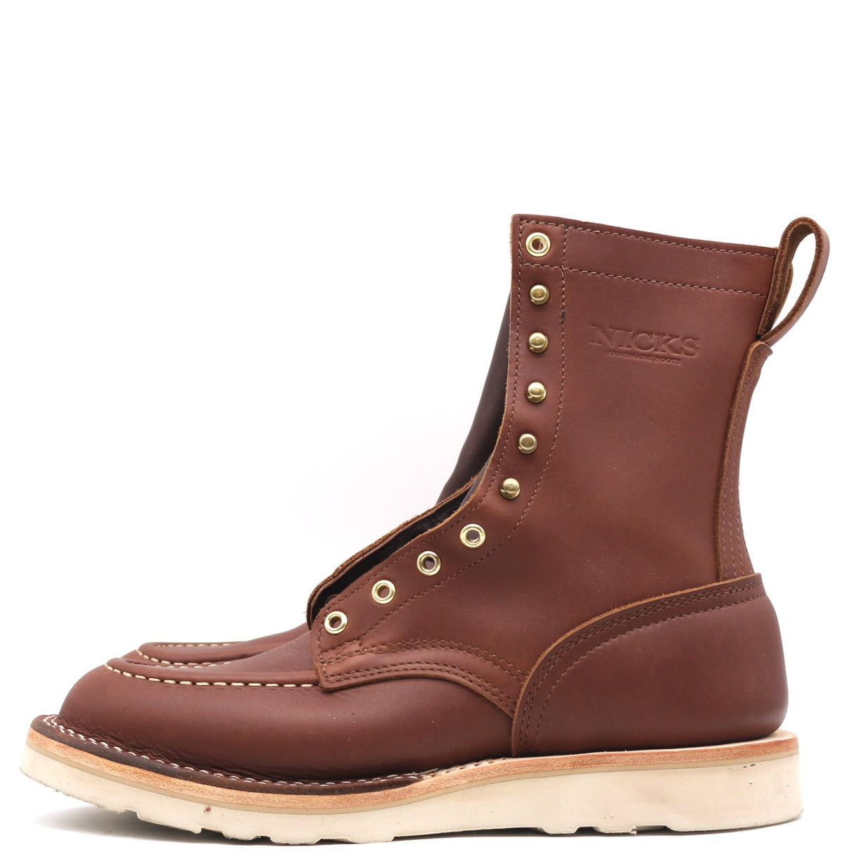Brown eight inch boots with a white outsole and brass hardware in front of a white background.