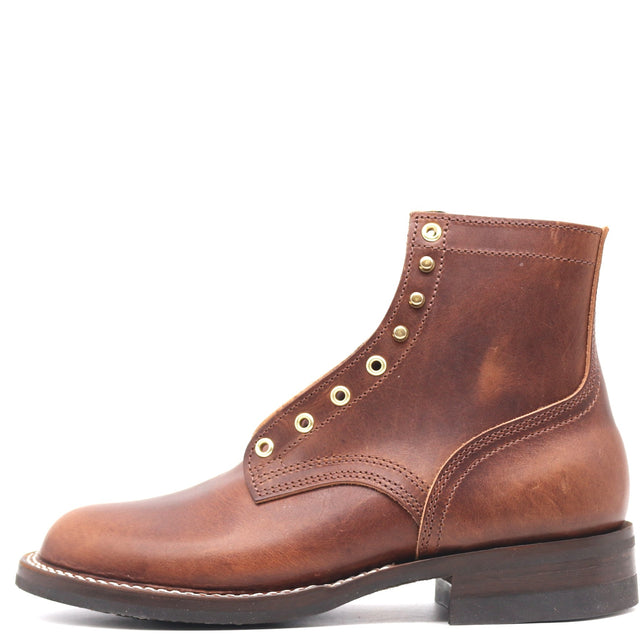 Side profile of a single brown ankle boot with brass hardware in front of a white background.