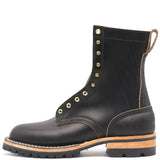 Side profile of a single black eight inch boot with brass hardware in front of a white background.