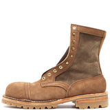 Photograph of one single tan leather boot with canvas uppers, a 4 row toecap, composite safety toe, and brass hardware in front of a white background.