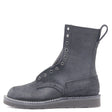 Black leather boot with a black wedge outsole, black hardware, a tactical heel counter and pull loop in front of a white background.
