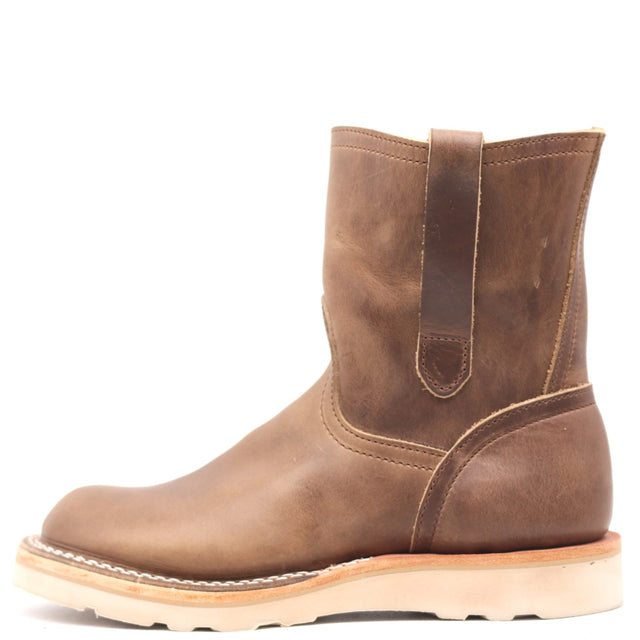 Light brown pull on boot with side pull loops and a white wedge outsole in front of a white background.