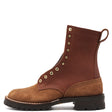 Brown work boot with lug outsole and brass hardware in front of a white background.