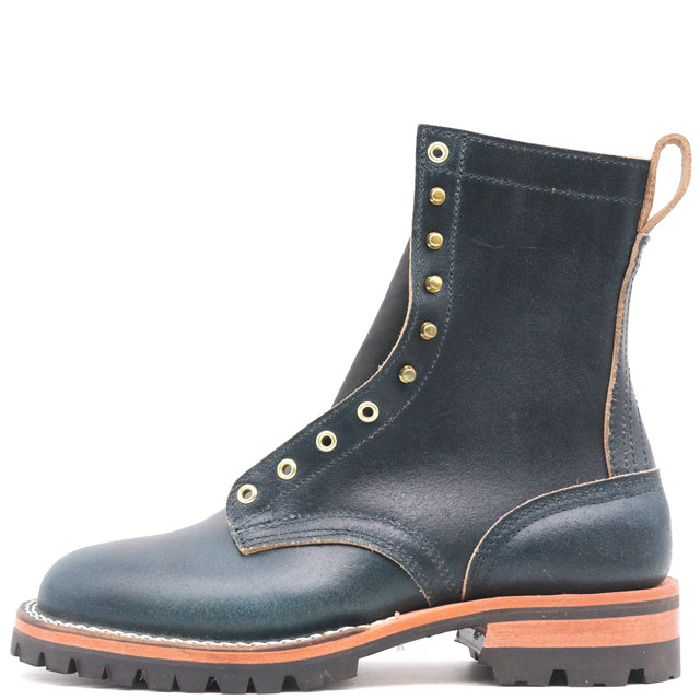 Photograph of a blue waxy leather with brass eyelets and a lug outsole in front of a white background.