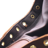 Close up photo of the gusset and eyelets of a brown boot. The fourth eyelet from the bottom has a cut in the leather underneath it.