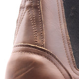 Close up of a two-piece brown leather boot backstay showing visible scuff marks.