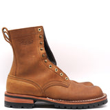 A single brown leather work boot with metal eyelets, a pull loop, and a black lug sole, photographed on a clean white background.