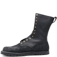A black leather and suede mid-calf work boot with brass eyelets and studs, featuring a pull tab and the brand name 'NICKS' embossed on the side, set against a plain white background.