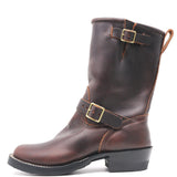 A dark brown leather mid-calf boot with gold-tone buckle straps, a low black block heel, and white contrast stitching, shown from a side profile on a white background.