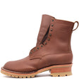 A brown leather lace-up ankle boot with metal eyelets, a pull loop, and a stacked lug sole, shown from the side on a white background. The brand name 'NICKS' is embossed on the side.