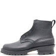 A black leather ankle boot with a rugged lug sole, side pull tab, and metal eyelets, shown from a side profile on a white background. The brand name 'NECKS' is embossed on the side.