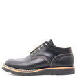 A black leather lace-up ankle boot with gold-tone metal eyelets, a tan welt, and a black sole, shown from a side profile on a white background.
