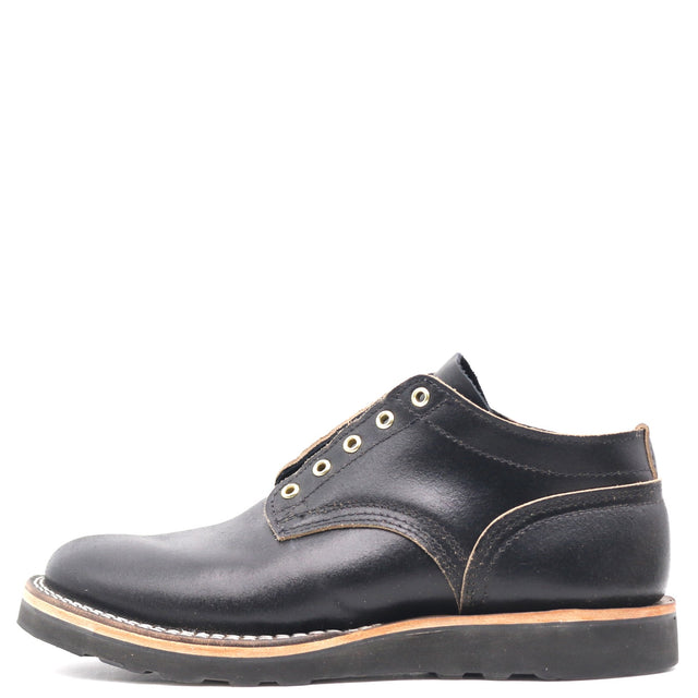 A black leather lace-up ankle boot with gold-tone metal eyelets, a tan welt, and a black sole, shown from a side profile on a white background.