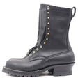 A black leather work boot with gold-tone metal eyelets, studs, and a pull tab, shown from a side profile on a white background. The brand name 'NICKS' is embossed on the side.
