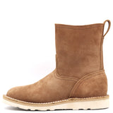 A single mid-calf ankle boot in brown suede, featuring a pull tab at the heel and a thick off-white sole with decorative stitching, shown against a plain white background.