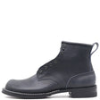 Dark blue boot with a rolled top and black hardware in front of a white background.