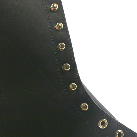 Close up of the uppers of a black boot showing the hardware. A circular indent can be seen in the leather.