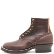Dark brown textured bison leather boot with brass hardware and classic heel stack in front of a white background.